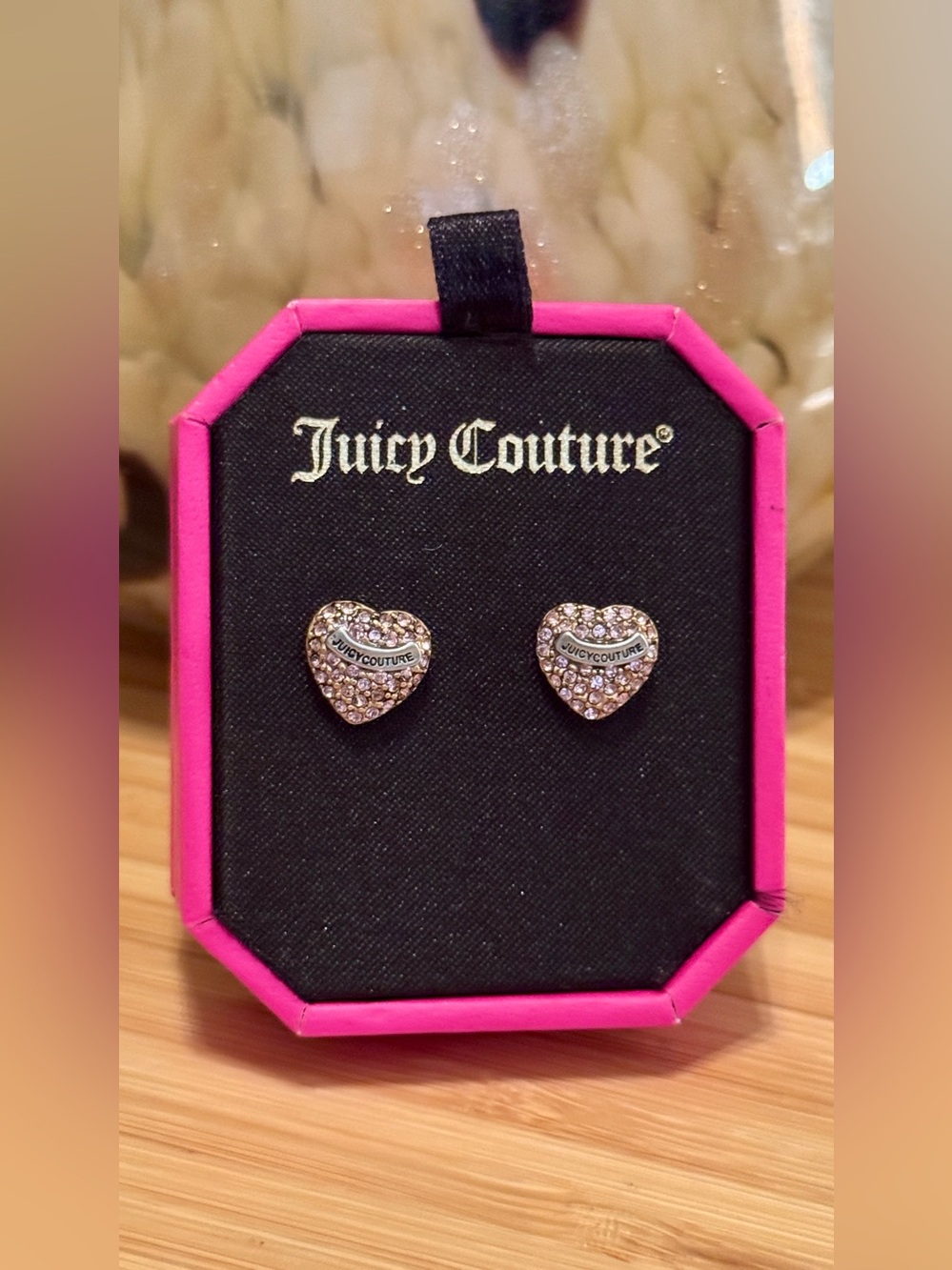 Juicy Couture heart stud earrings feature rhinestone accents and a banner logo.